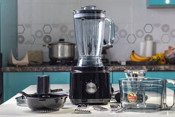Natural light. black food processor. Near the nozzle for use. In the background is a kitchen for cooking