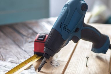 Stüdyo ışıkları. Elektrikli tornavida. Geçmişe dönük ahşap bir arka plan. Yumuşak odaklanma. Yakın plan.