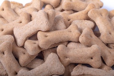 Stüdyo ışıkları. Kemik şeklinde köpek maması. Beyaz bir arkaplanda