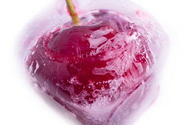 Arka plan beyaz. Buzlu kırmızı kirazlar. Yakın plan. Makro