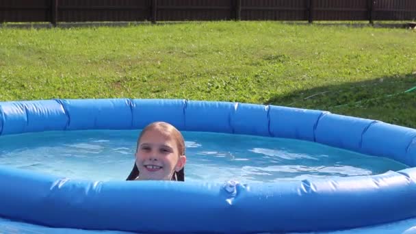 自然光よ 明るい太陽 水着姿の女の子が小さなプールで泳いでいる — ストック動画