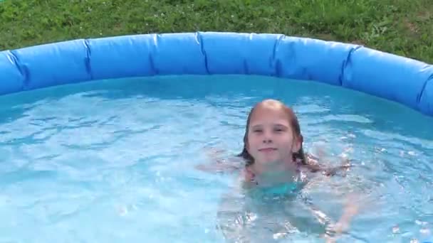 自然光よ 明るい太陽 水着姿の女の子が小さなプールで泳いでいる — ストック動画
