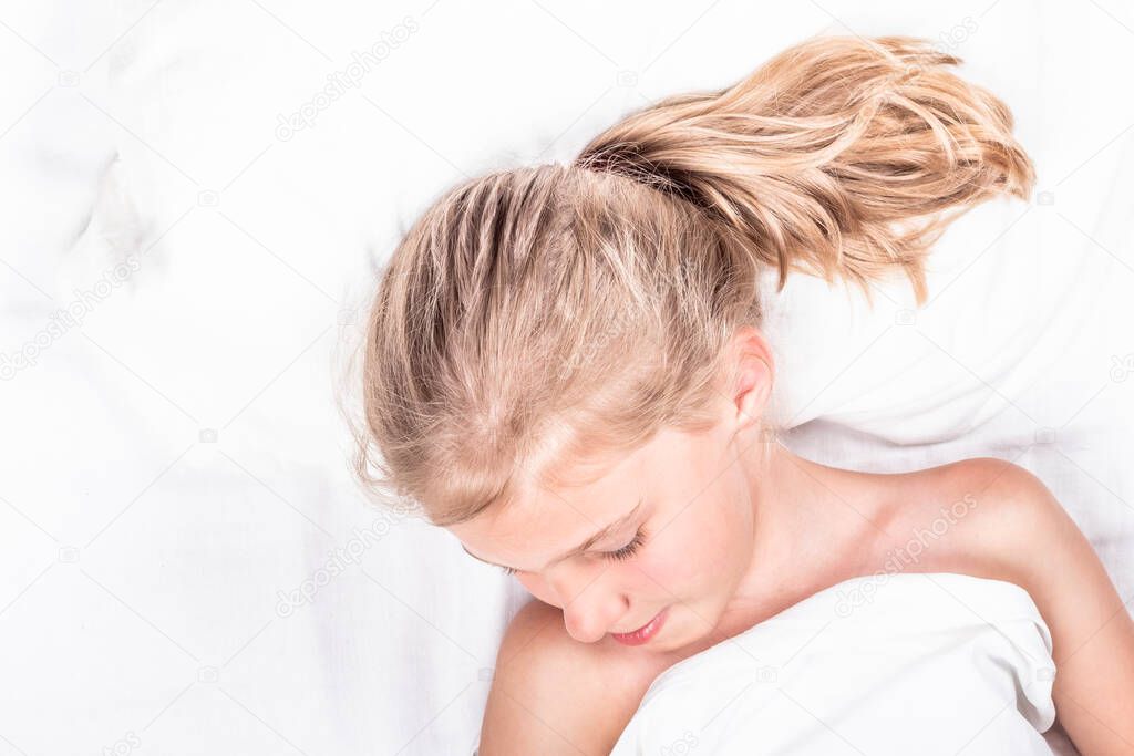 A girl with white hair. He is lying in a white bed. close-up