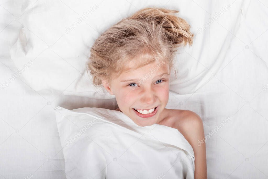 A girl with white hair. He is lying in a white bed, smiling. Looking at us. close-up