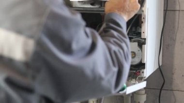 Usta duvara asılı bir gaz kazanı kuruyor. Ön torpido gözü açık. Isıtma ayarlandı ve başladı..