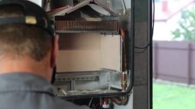 Usta duvara asılı bir gaz kazanı kuruyor. Ön torpido gözü açık. Isıtma ayarlandı ve başladı..