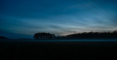 İsveç 'te mavi gökyüzü boyunca uzanan elektrik hattı