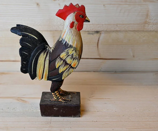 Gallo de madera hecho a mano de pie en banco de madera — Foto de Stock