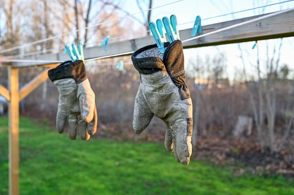 Par de guantes de trabajo que cuelgan para secar en un estante de secado — Foto de Stock