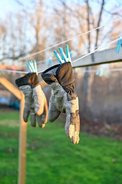 Par de guantes de trabajo que cuelgan para secar en un estante de secado — Foto de Stock