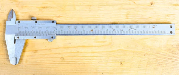 Pinza con centimetro e millimetro su panca in legno — Foto Stock