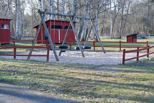 Качели в игровой зоне для детей в апреле — стоковое фото
