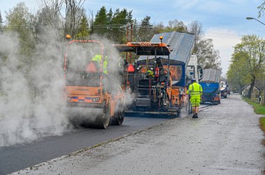 İsveç 'te yol kenarında asfalt döşeyen yol işçisi
