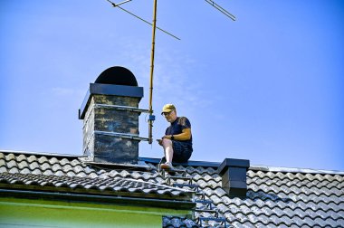 Eski bir televizyon antenini indiren bir adam.