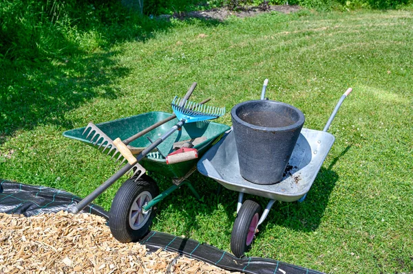 Skottkärror fulla av trädgårdsredskap på gräsmattan — Stockfoto