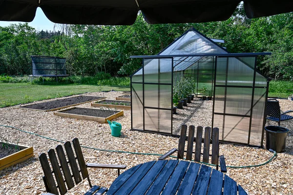 庭にサンシェード付きの温室テーブルと椅子 — ストック写真