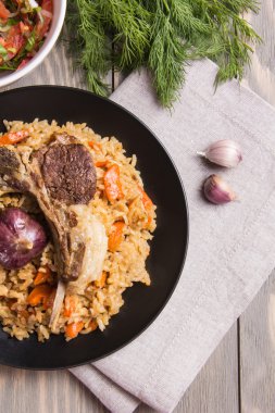 Geleneksel pilav et ve ahşap bir masa üzerinde sarımsak ile