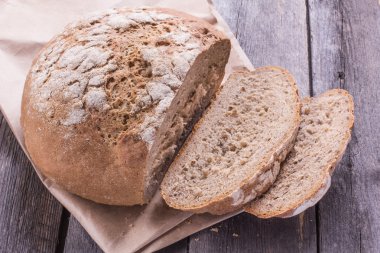 Ahşap masa üzerinde eski bir somun ekmek dilimlenmiş