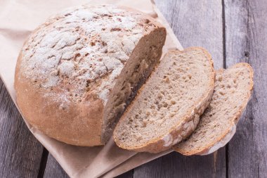Ahşap masa üzerinde eski bir somun ekmek dilimlenmiş