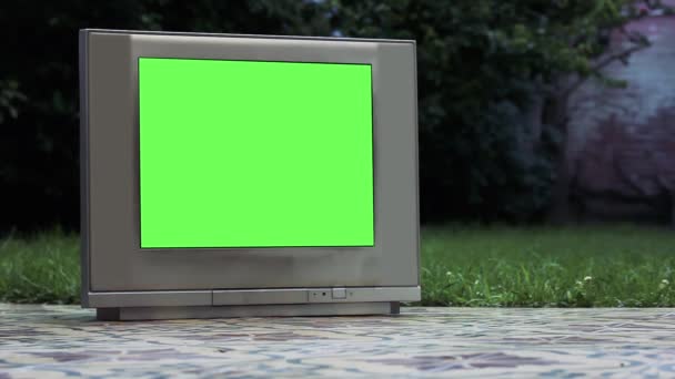 家の裏庭に緑の画面を持つ古いグレーのテレビ 緑の画面を必要な映像や画像に置き換えることができます Effectsやその他のビデオ編集ソフトウェアのキーエフェクトで実行できます — ストック動画