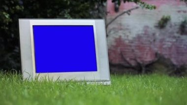 Yeşil Çimenli Mavi Ekran 'lı eski televizyon. Mavi ekranı istediğiniz görüntüyle ya da resimle değiştirebilirsiniz. Sonraki Efektler ya da herhangi bir video düzenleme yazılımında Keying efekti ile yapabilirsiniz (YouTube 'daki derslere bakın).  