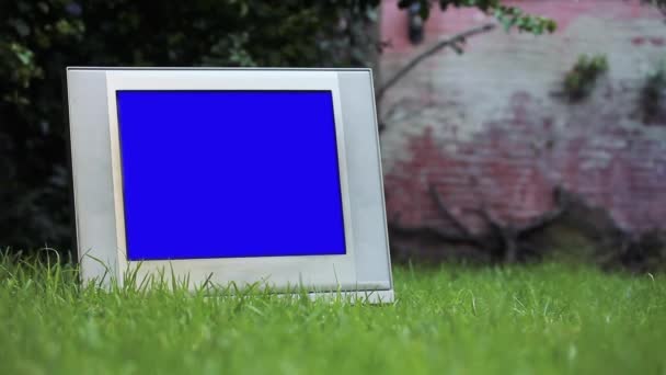 Régi TV kék vetítővászonnal Green Grass-ben. Kicserélheti a kék képernyőt a felvételre vagy képre, amit akar. Meg tudod csinálni a Keying hatás After Effects vagy bármely más videó szerkesztő szoftver (nézd meg útmutatók a YouTube-on).  