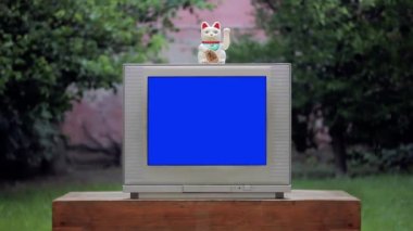 Bir Maneki Neko Şanslı Kedi Mavi Ekranlı Eski Televizyonun Üzerinde. Yakınlaştır. Mavi ekranı istediğiniz görüntüyle ya da resimle değiştirebilirsiniz. Sonraki Efektler ya da diğer herhangi bir video düzenleme yazılımında Keying efekti ile yapabilirsiniz. 
