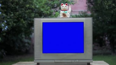 Maneki Neko Şanslı Kedi Mavi Ekranlı Eski Televizyonun Üzerinde. Mavi ekranı istediğiniz görüntüyle ya da resimle değiştirebilirsiniz. Sonraki Efektler ya da herhangi bir video düzenleme yazılımında Keying efekti ile yapabilirsiniz (YouTube 'daki derslere bakın). 