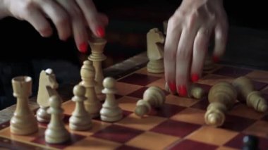 Female Hands with Painted Nails setting Up a Carved Chess Board. Close-Up.  