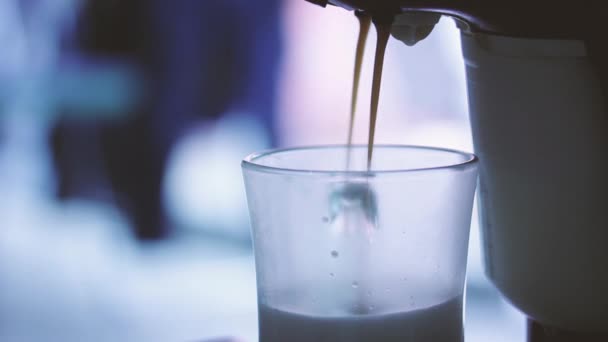 エスプレッソマシンはホットミルクとコーヒーをコーヒーカップに注ぎます クローズアップ — ストック動画