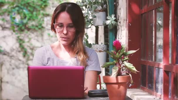 Kadını Dışarıda Oturuyor Pembe Dizüstü Bilgisayarla Çalışıyor — Stok video