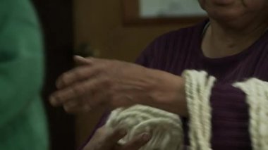 Arjantin 'deki bir And Okulu' nda yün iplik tutan eller. Yakın plan.  