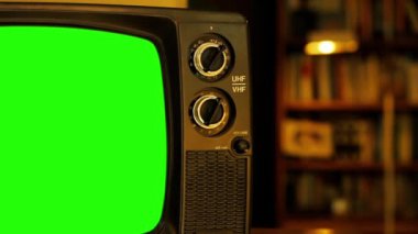 Man Hand eski televizyonu yeşil ekran ile akort ediyor. Yakın plan. Yeşil ekranı istediğin görüntüyle ya da resimle değiştirebilirsin. Sonraki Efektler ya da herhangi bir video düzenleme yazılımında Keying efekti ile yapabilirsiniz (YouTube 'daki derslere bakın).  