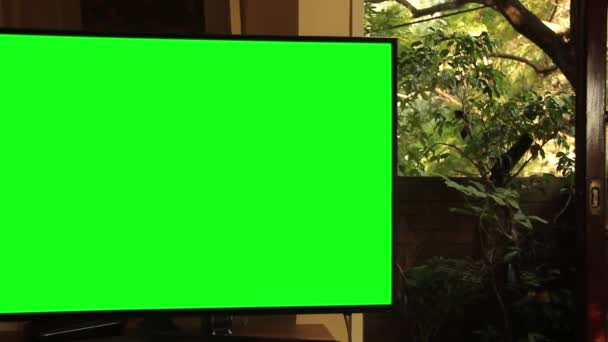 リビングで緑の画面を持つスマートテレビ ズームイン 緑の画面を必要な映像や画像に置き換えることができます Effectsやその他のビデオ編集ソフトウェアでキーエフェクトを使用することができます Youtubeでチュートリアルを確認してください — ストック動画