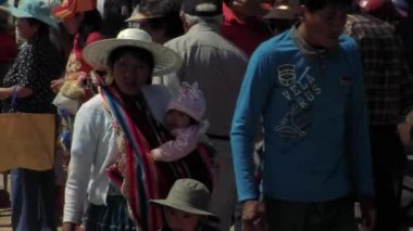 Bolivyalı Aile Bolivya 'daki Urkupina Bakiresi Festivali' nde kalabalığın arasında yürüyor.  