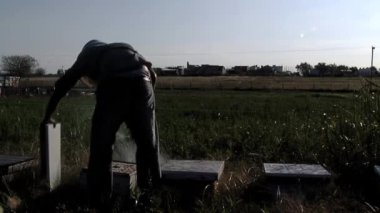Apiary 'de Kovan Çerçevesini inceleyen bir arı yetiştiricisi, Arı Kovanı Çerçevesi ve Arı İçicisi' ni tutan bir adam, Kovan içen bir arı yetiştiricisi.. 