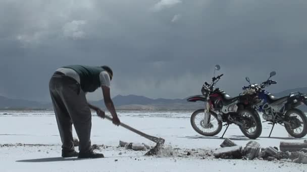 塩鉱夫は 南米アルゼンチンのサルタにあるサリナス グランデ グレート ソルト フラット から塩地殻を切断します — ストック動画