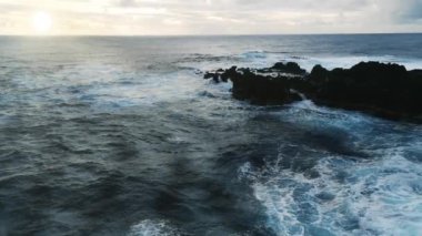 Güney Amerika 'daki Rapa Nui, Paskalya Adası' ndaki Hanga Roa yakınlarındaki Ana Kai Tangata Mağarası 'nın önündeki kayalıklarda dalgalar kopuyor. Ağır çekim. 4K. 