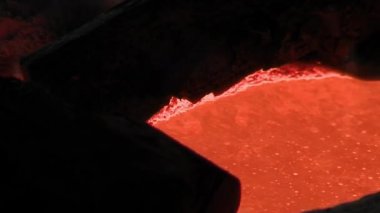 Bir çan üretim fabrikasının fırınında erimiş metal. Kapat..  