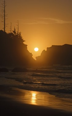 Batan güneşin kıyı kayaların üzerinden