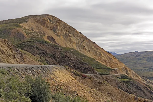 Toprak yol engebeli bir dağ geçidi aracılığıyla — Stok fotoğraf