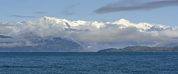 Λευκό χιονοσκέπαστες κορυφές που εμφανίζεται πίσω από τα σύννεφα το πρωί — Φωτογραφία Αρχείου