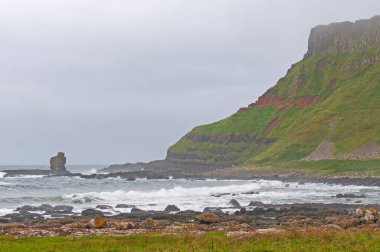 Kuzey İrlanda 'da, Giants Geçidi' nin yakınındaki sisli bir sahilde engebeli uçurumlar.