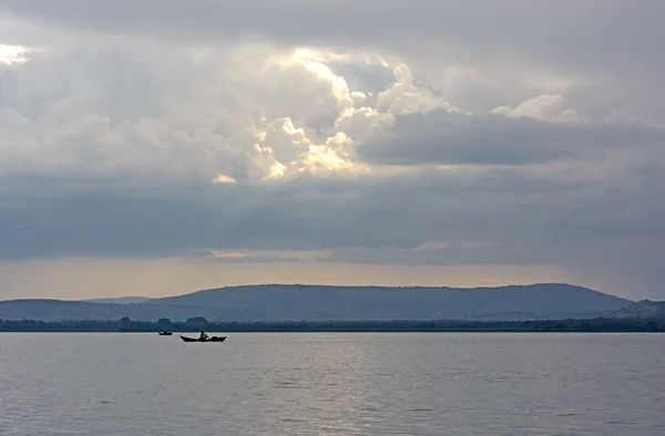在日落时的远程湖上的渔民 — 图库照片