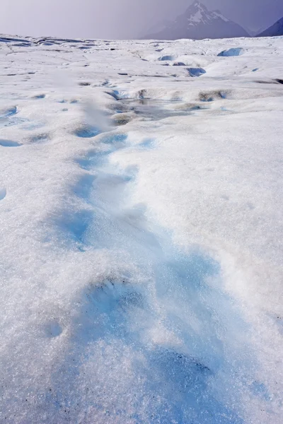 Corriente sobre el hielo azul y blanco de un glaciar alpino — Foto de Stock