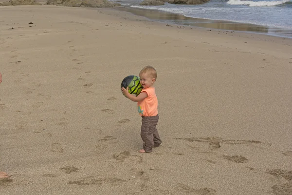 Bambina che gioca con una palla sulla spiaggia — Foto Stock