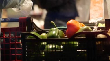 Yaşlı bir kadın eline bir dolma biber alıp el arabasına koyar..