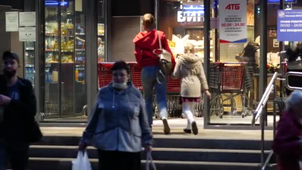 Einkäufer gehen durch die Türen eines Lebensmittelmarktes ein und aus — Stockvideo