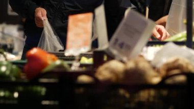 Son sınıf bayan alışverişçi süpermarkette yeşil biber seçiyor. Yaşlı bir kadın.