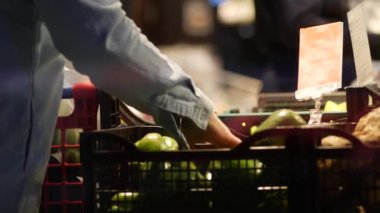 Son sınıf bayan alışverişçi süpermarkette yeşil biber seçiyor. Yaşlı bir kadın.